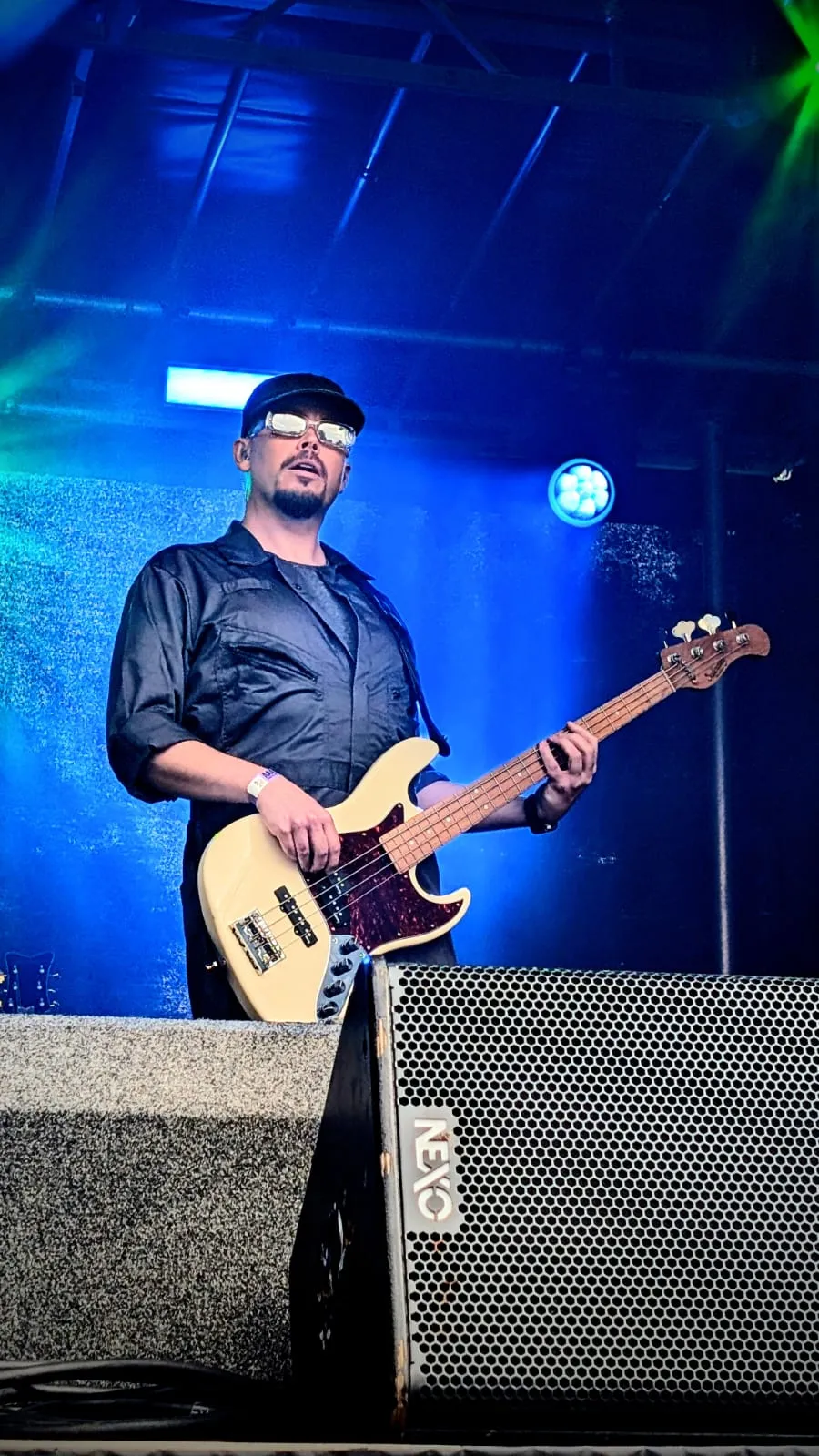 U2.V2 bassist playing a cream bass under blue stage lights at the Ultimate Festival, Dumfries