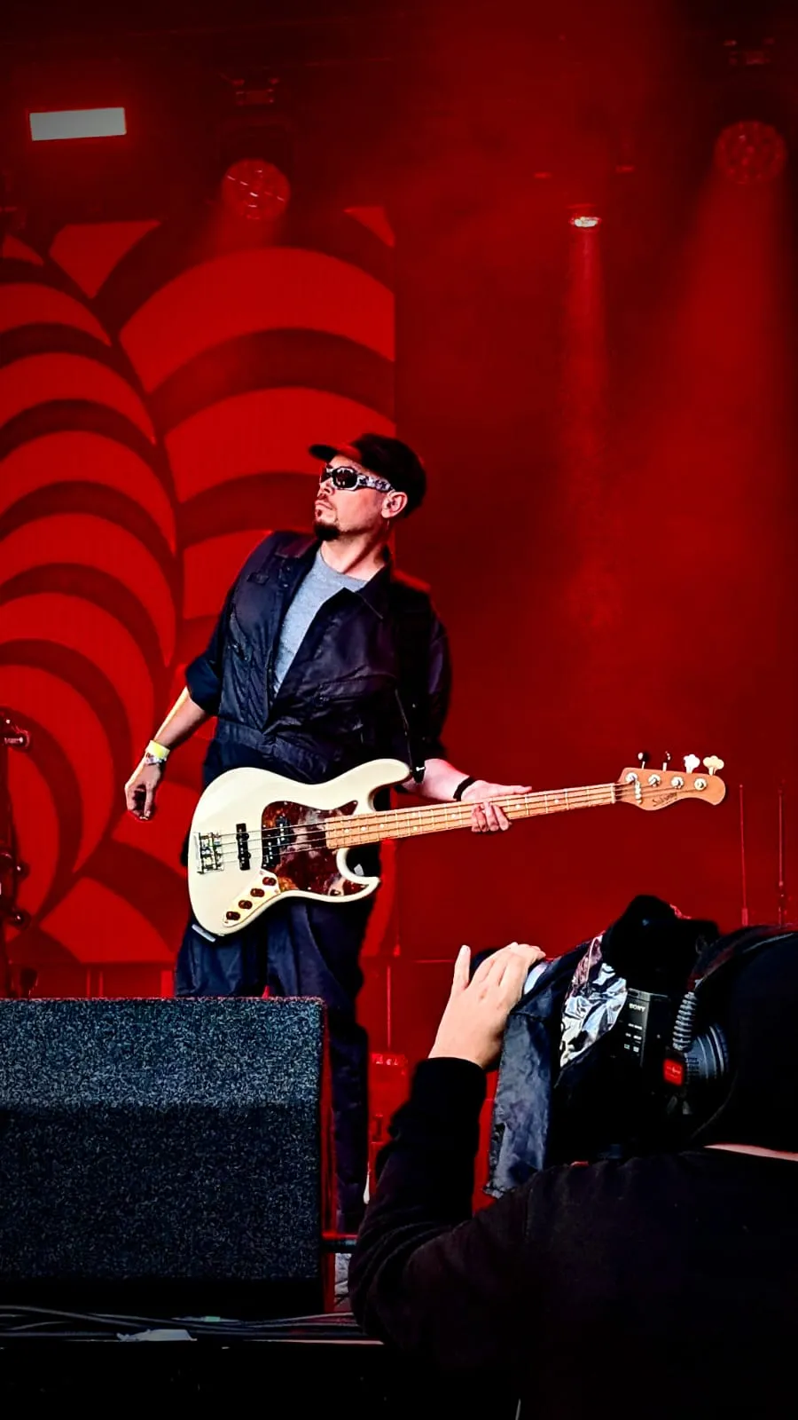 U2.V2 bassist on the Tribfest main stage against a red backdrop